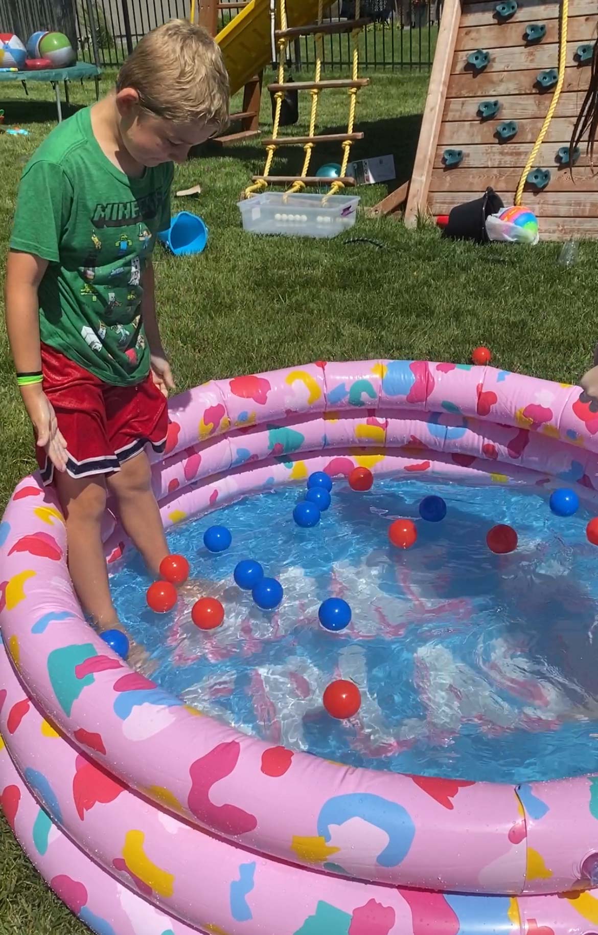 kid standing in a pool with balls