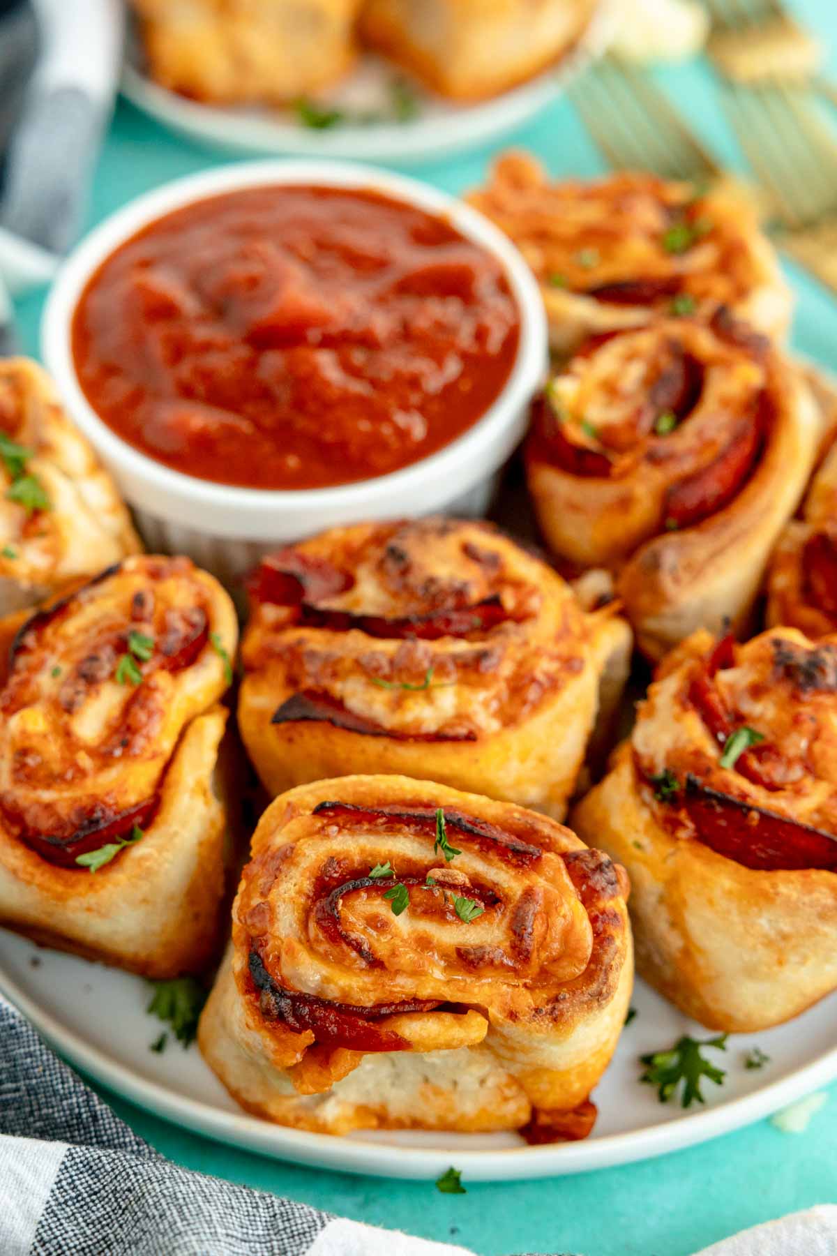 pepperoni rolls with pizza sauce on a teal plate