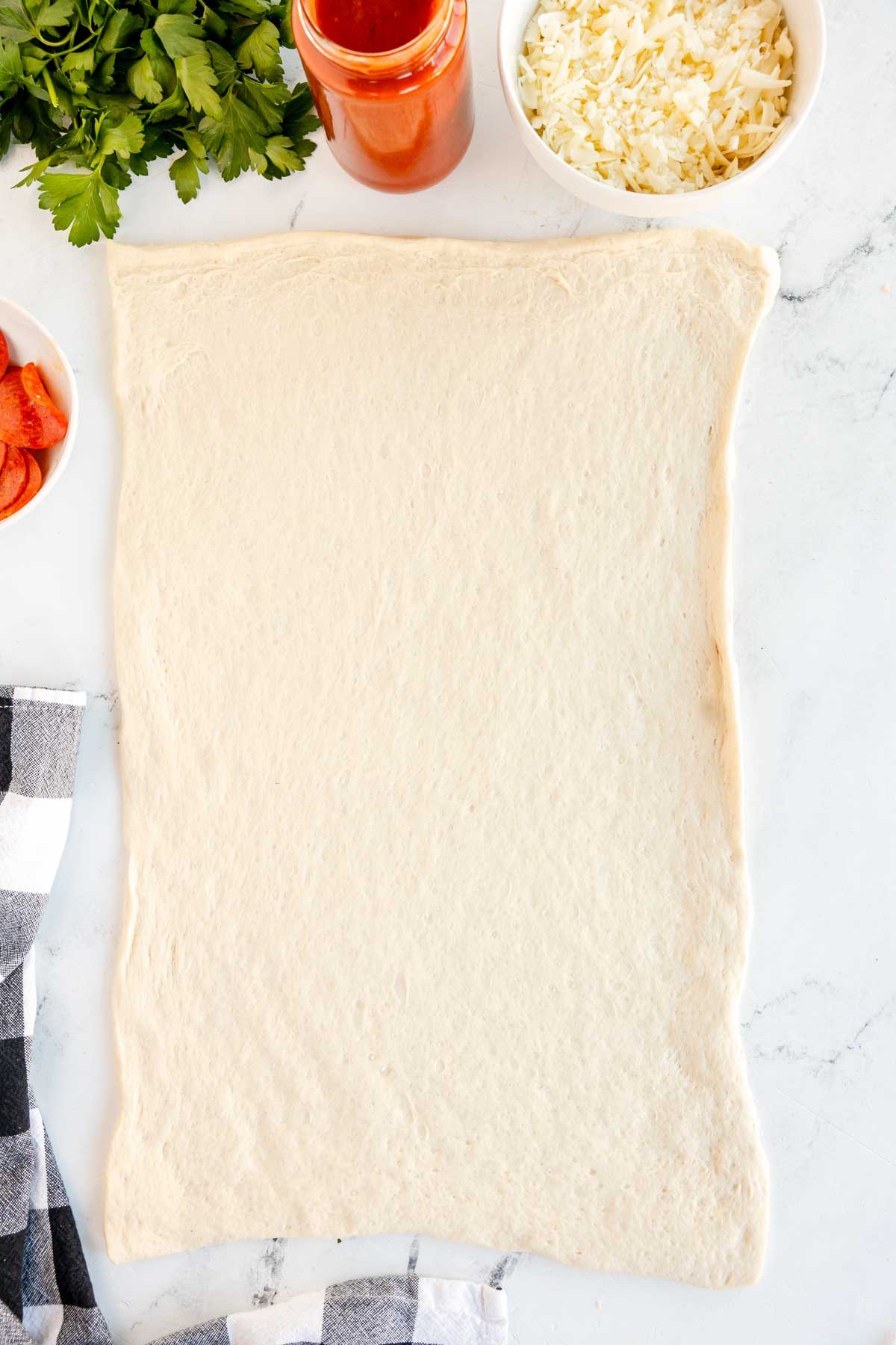 pizza dough rolled into a large rectangle