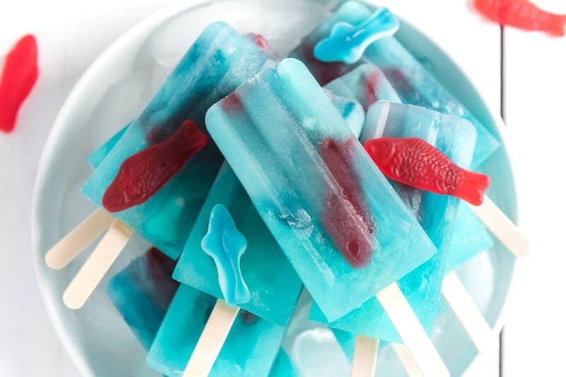 A horizontal photo of a pile of blue lemonade popsicles on top of each other