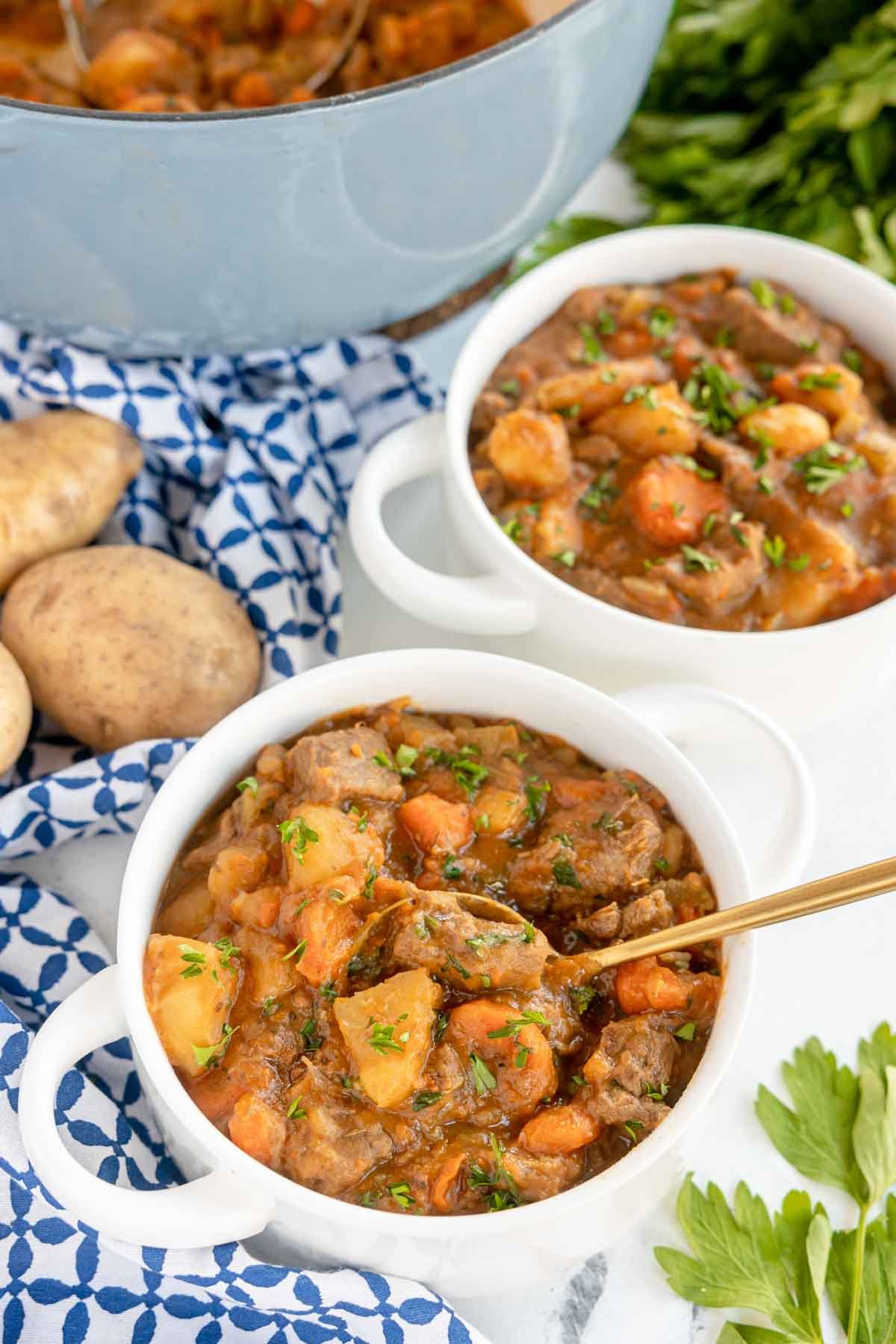 two bowls of beef stew with potatoes and carrots