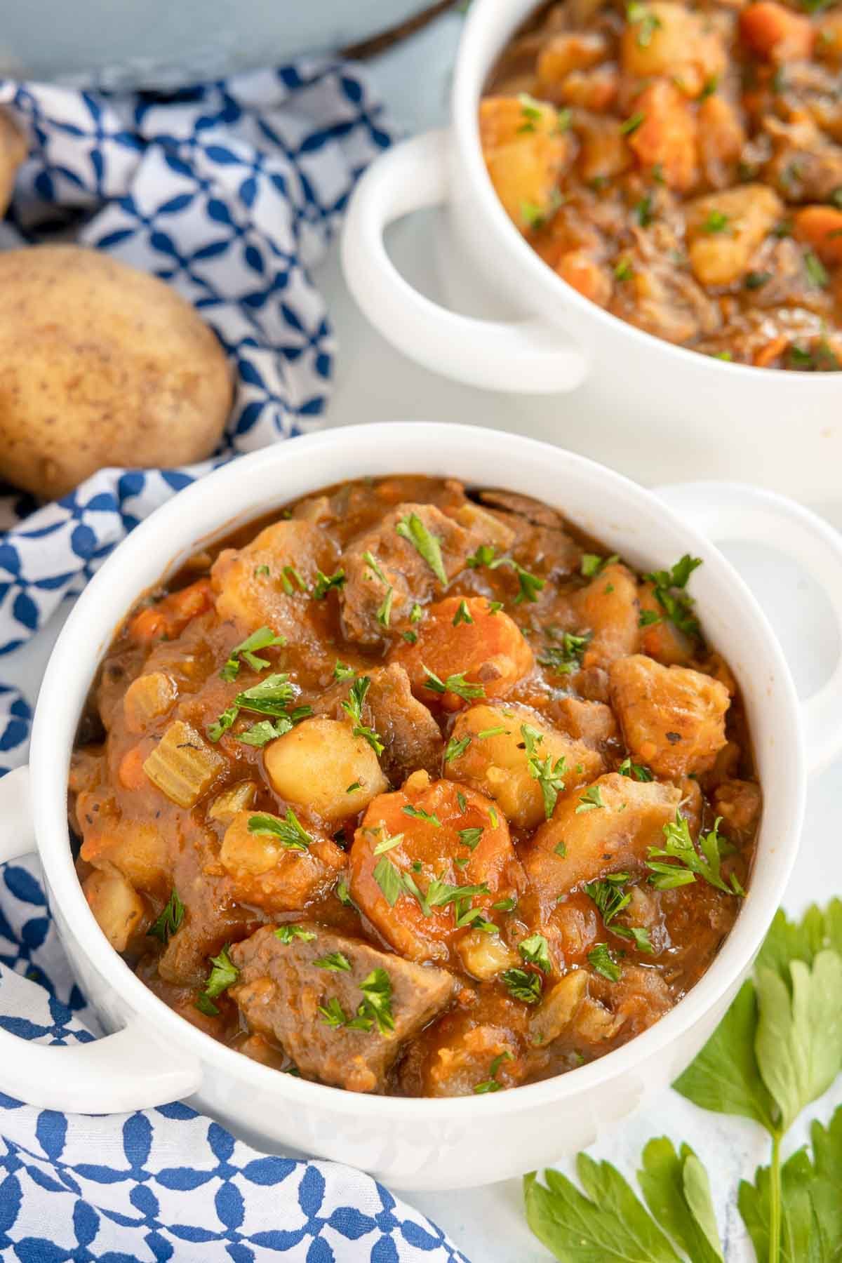 white bowl filled with beef stew with potatoes