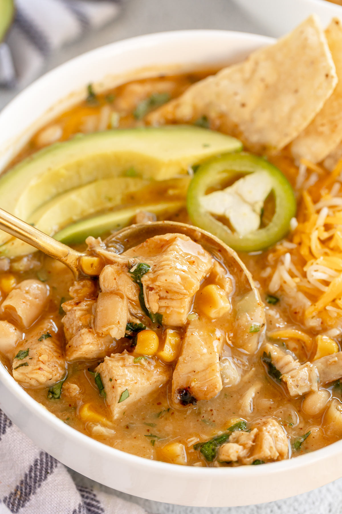 bowl of dairy free white chicken chili with a spoon coming out of it