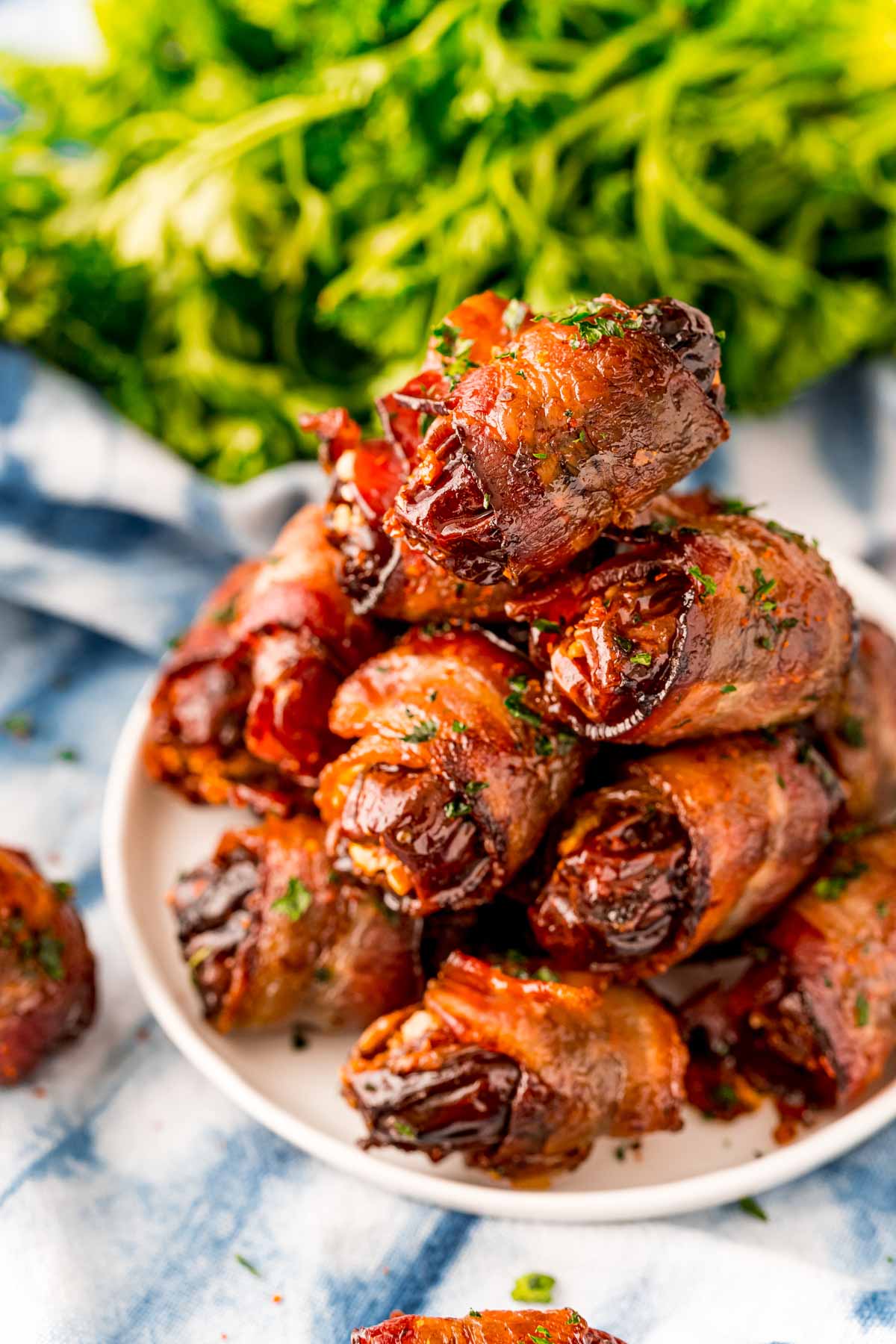 White plate with a stack of bacon wrapped dates