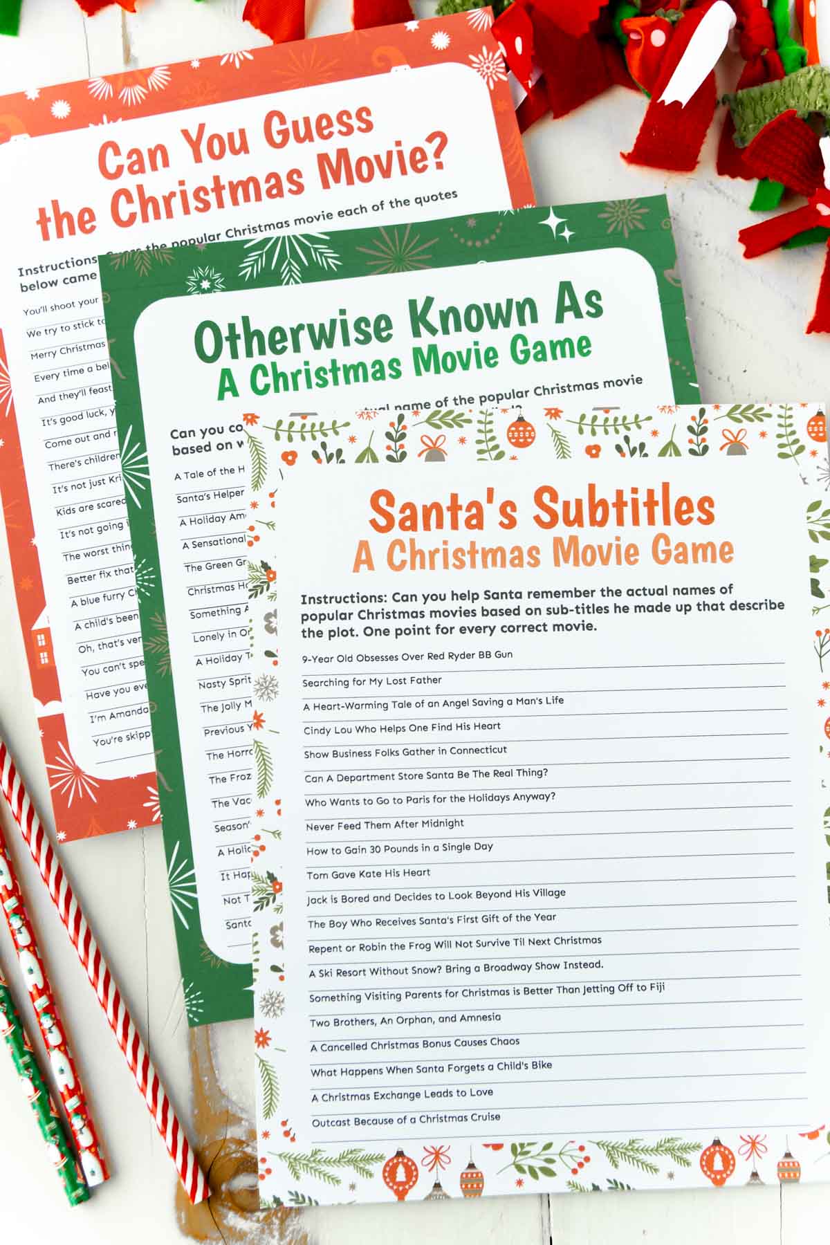 Three Christmas movie trivia games on top of each other