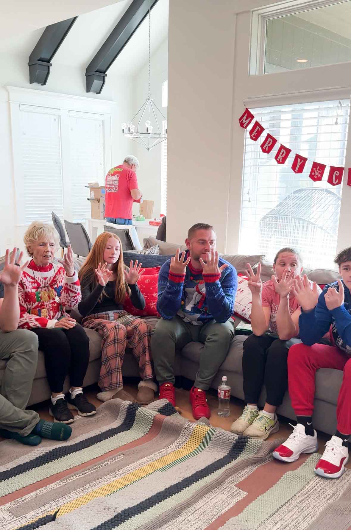 a bunch of adults sitting on a couch with fingers held up