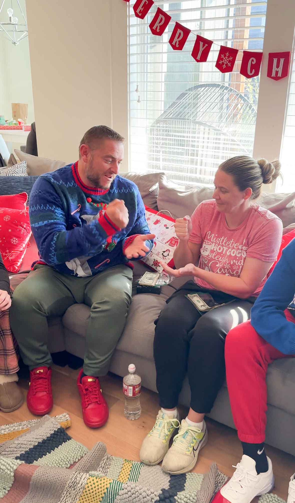 woman and man sitting on a couch playing rock paper scissors