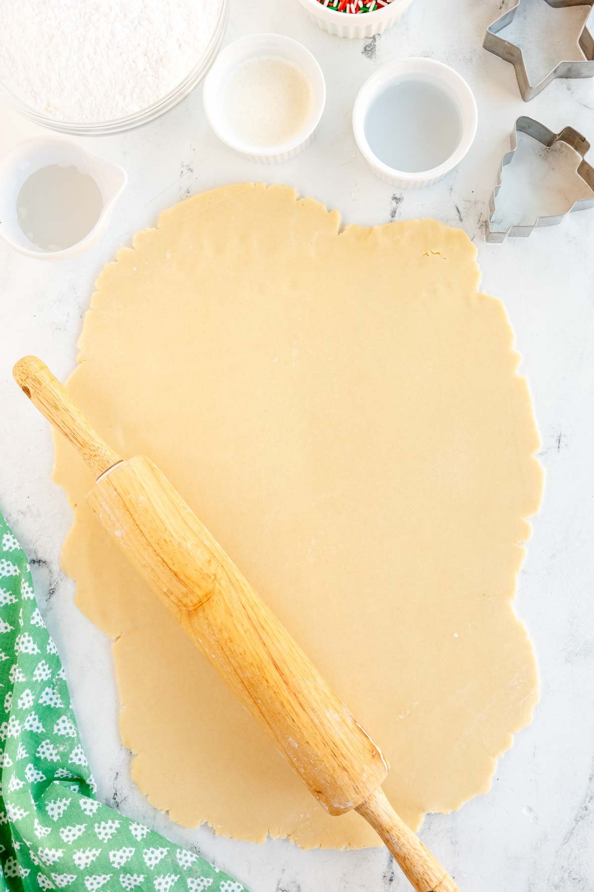 sugar cookie dough rolled out on a white surface