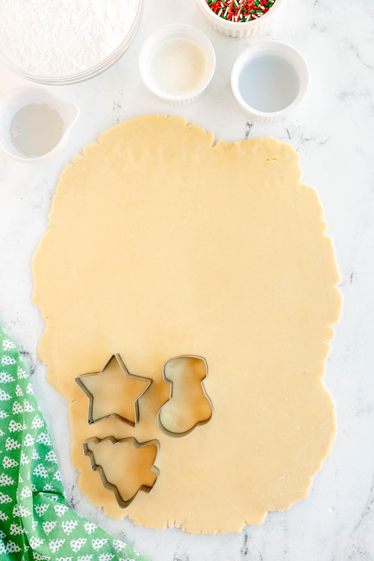 cookie cutters on rolled out cream cheese sugar cookie dough