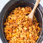 stirring ranch chex mix in a slow cooker