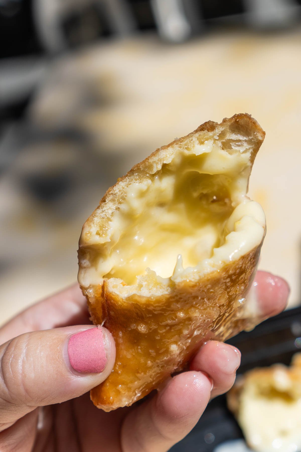 hand holding a lemon filled beignet from Disneyland