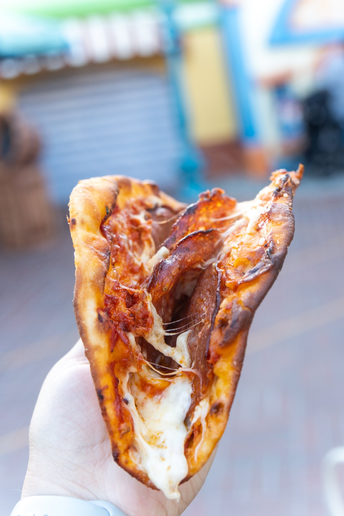 hand holding a pepperoni pizza flopover from Disneyland