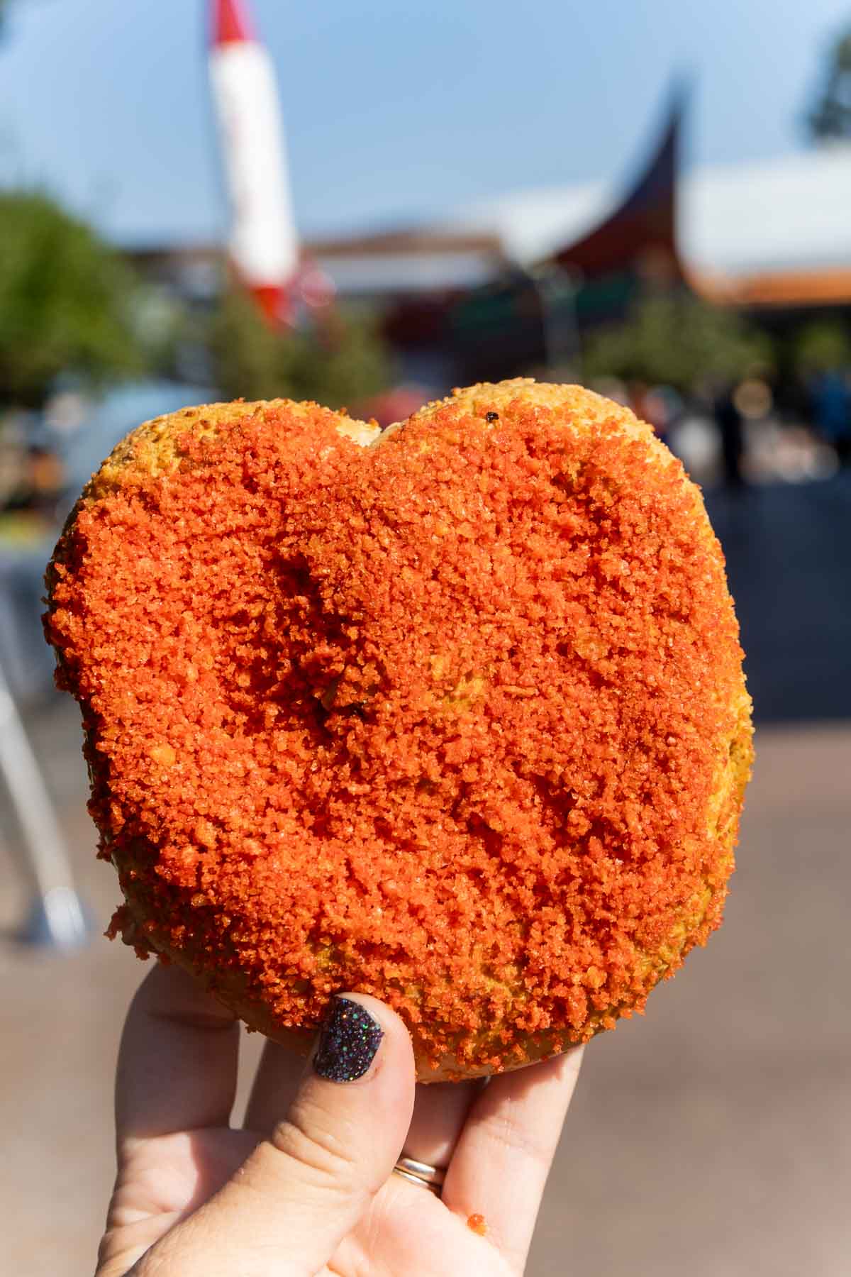 hand holding a pretzel coated in Hot Cheetos