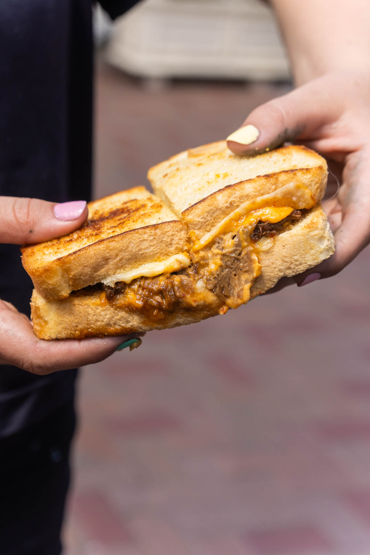 hand holding a toasted bugogi sandwich at disneyland