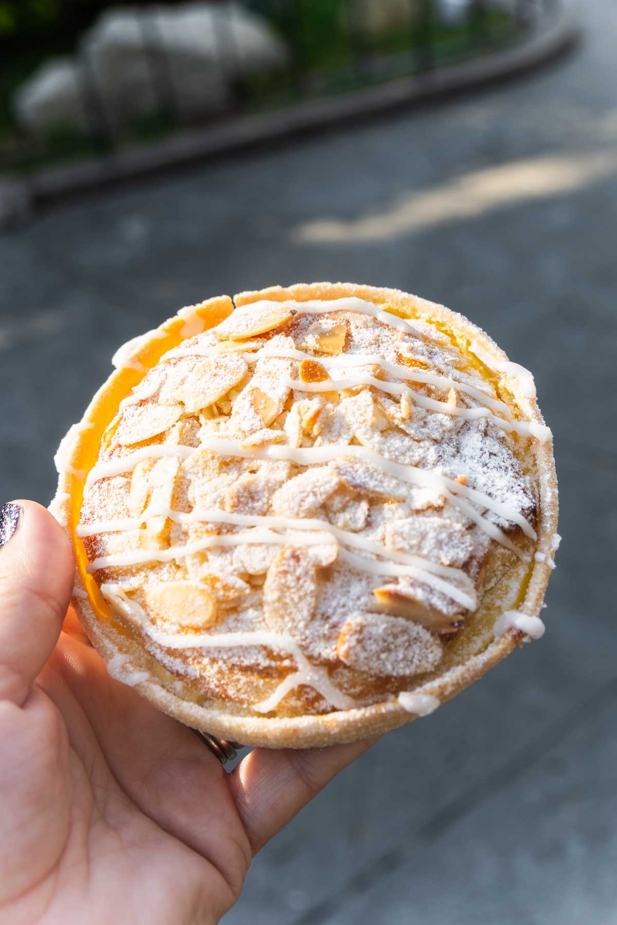 hand holding an almond tart at Disneyland