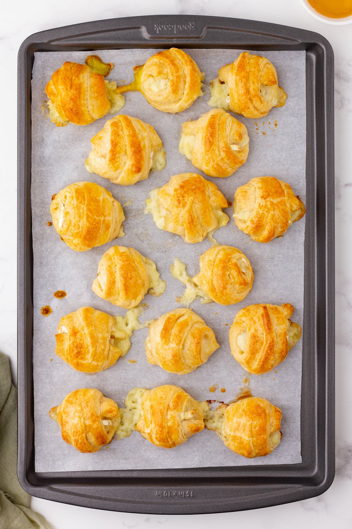 golden brown brie and pear appetizers on a baking sheet