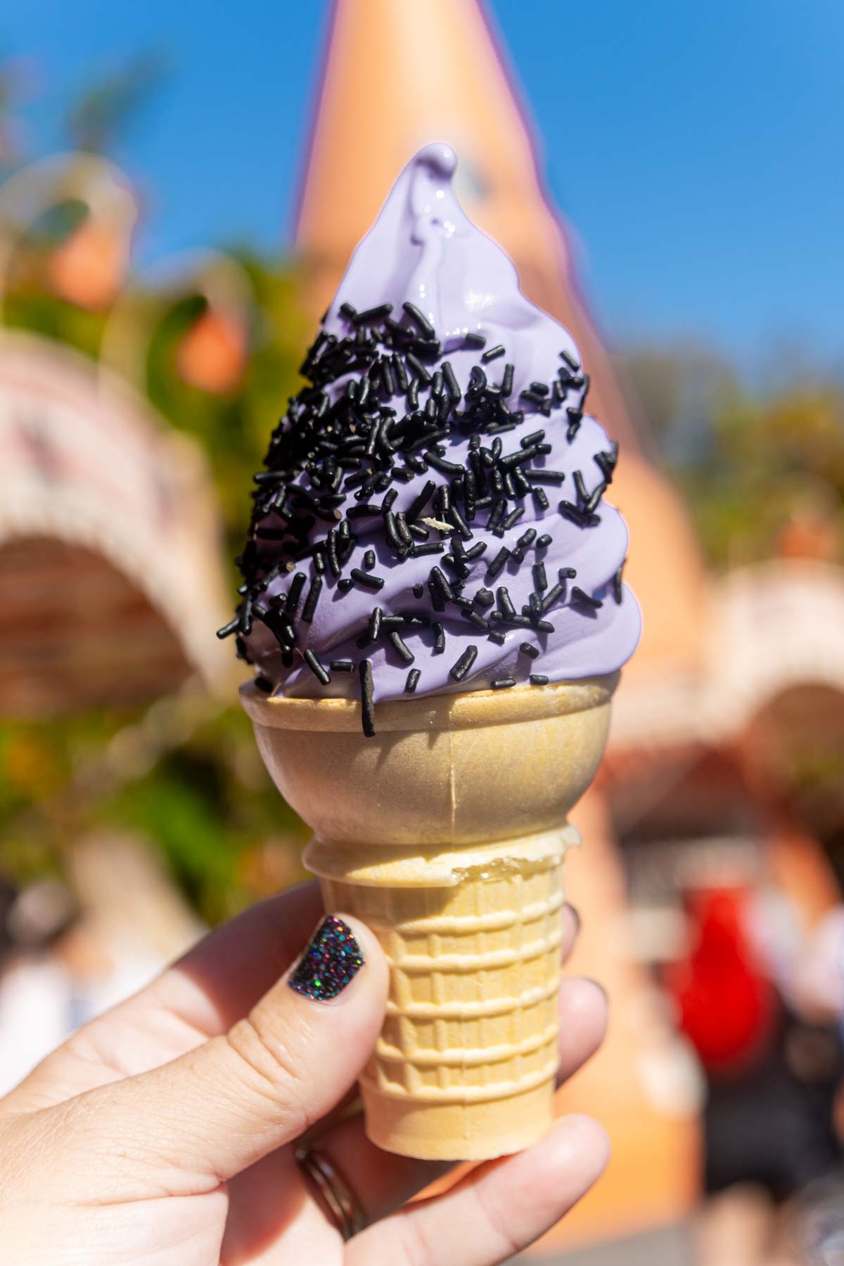 hand holding an ube soft serve ice cream cone at Disneyland