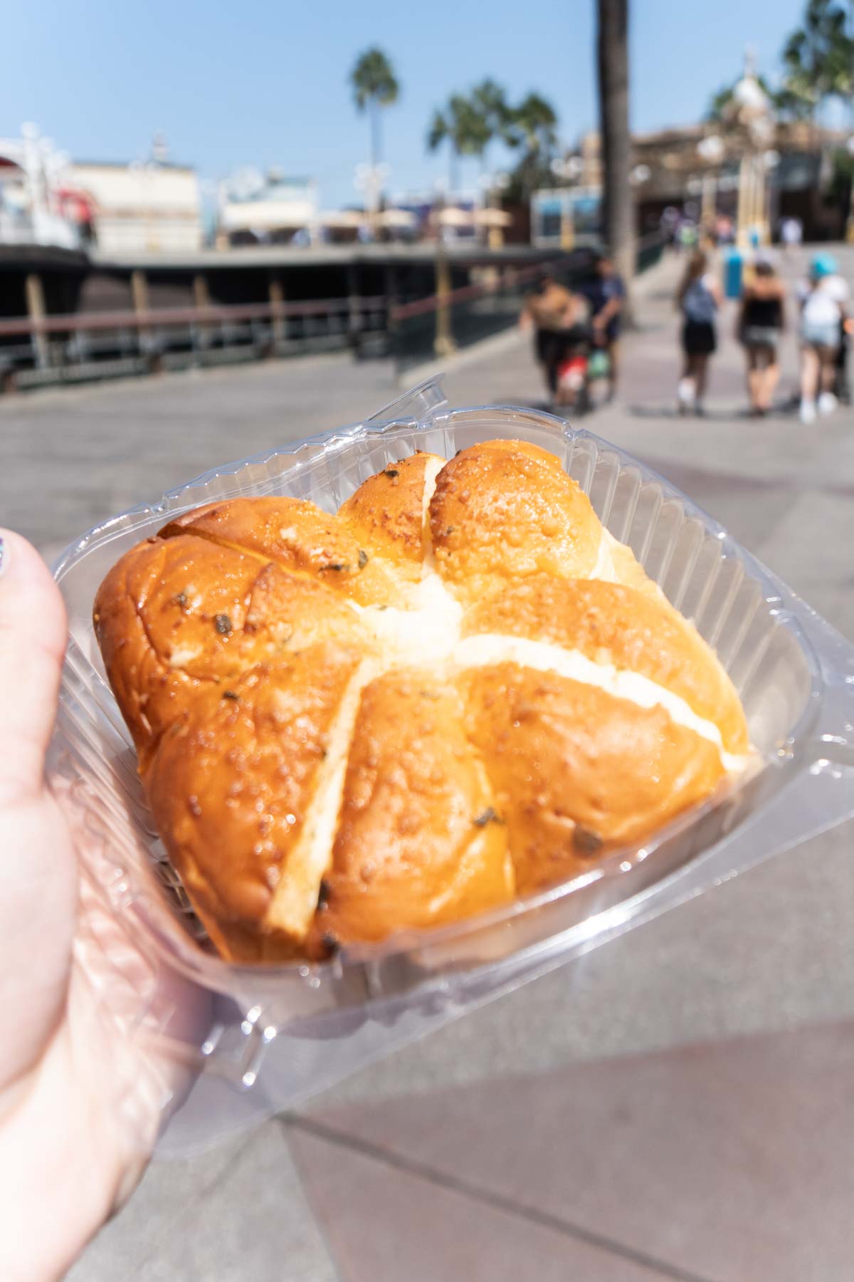 Hand holding a cream cheese bread at Disneyland