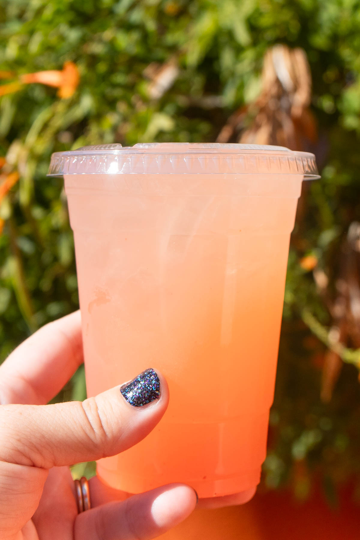 hand holding a glass of cucumber jalapeno lemonade