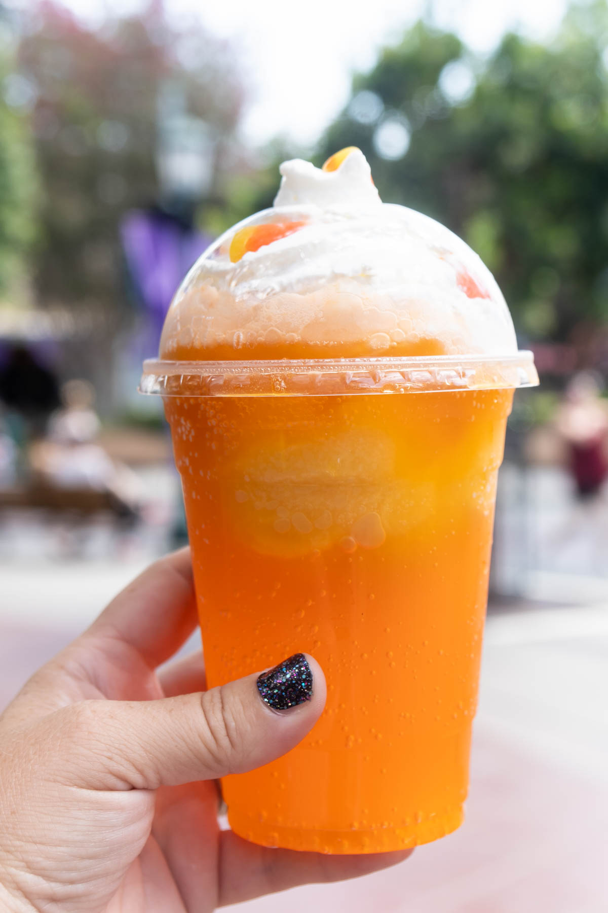 hand holding a candy corn float at Disneyland