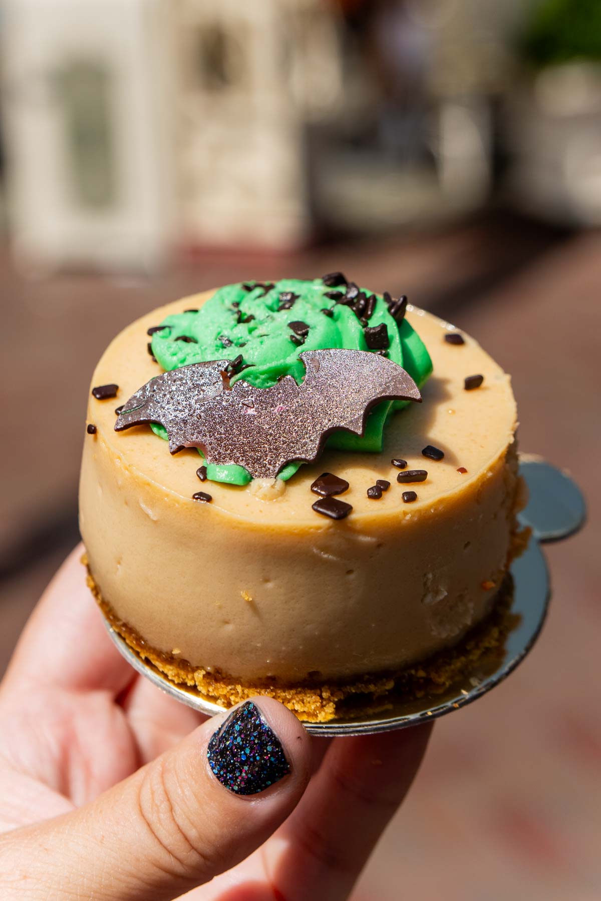 Hand holding a caramel apple cheesecake at Disneyland