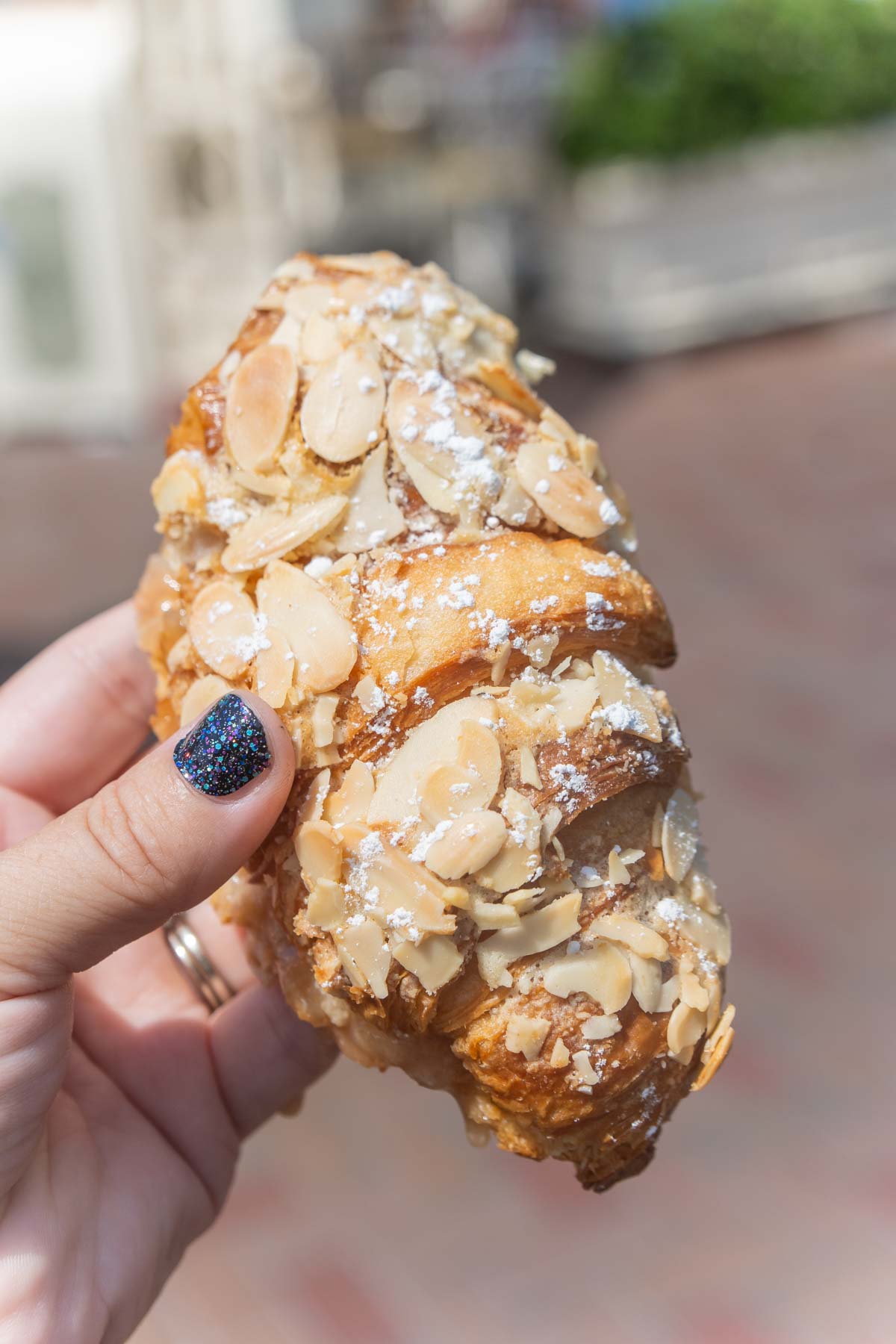 hand holding an apple almond croissant from Disneyland