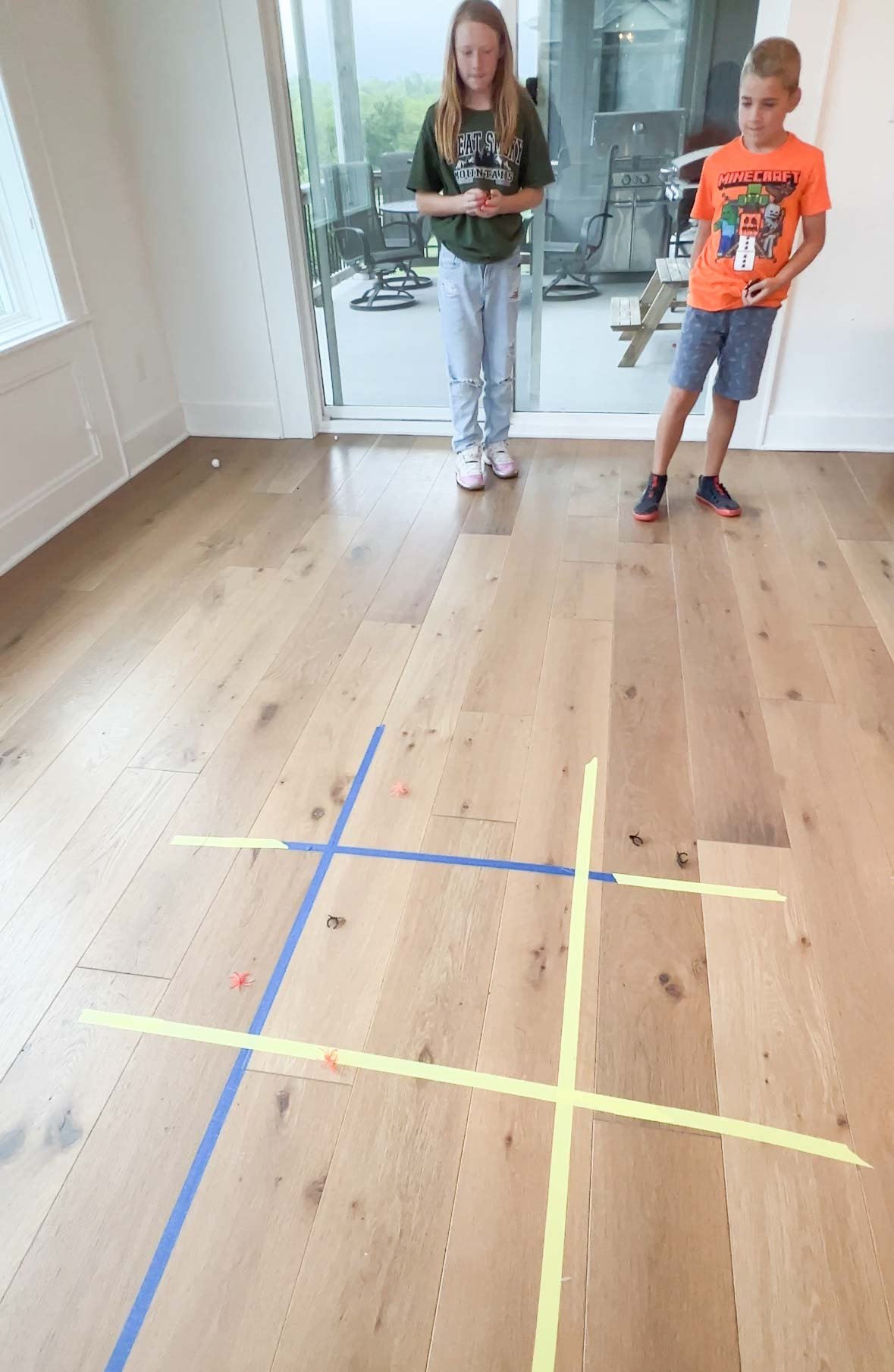 tic tac toe board made out of tape on a hardwood floor