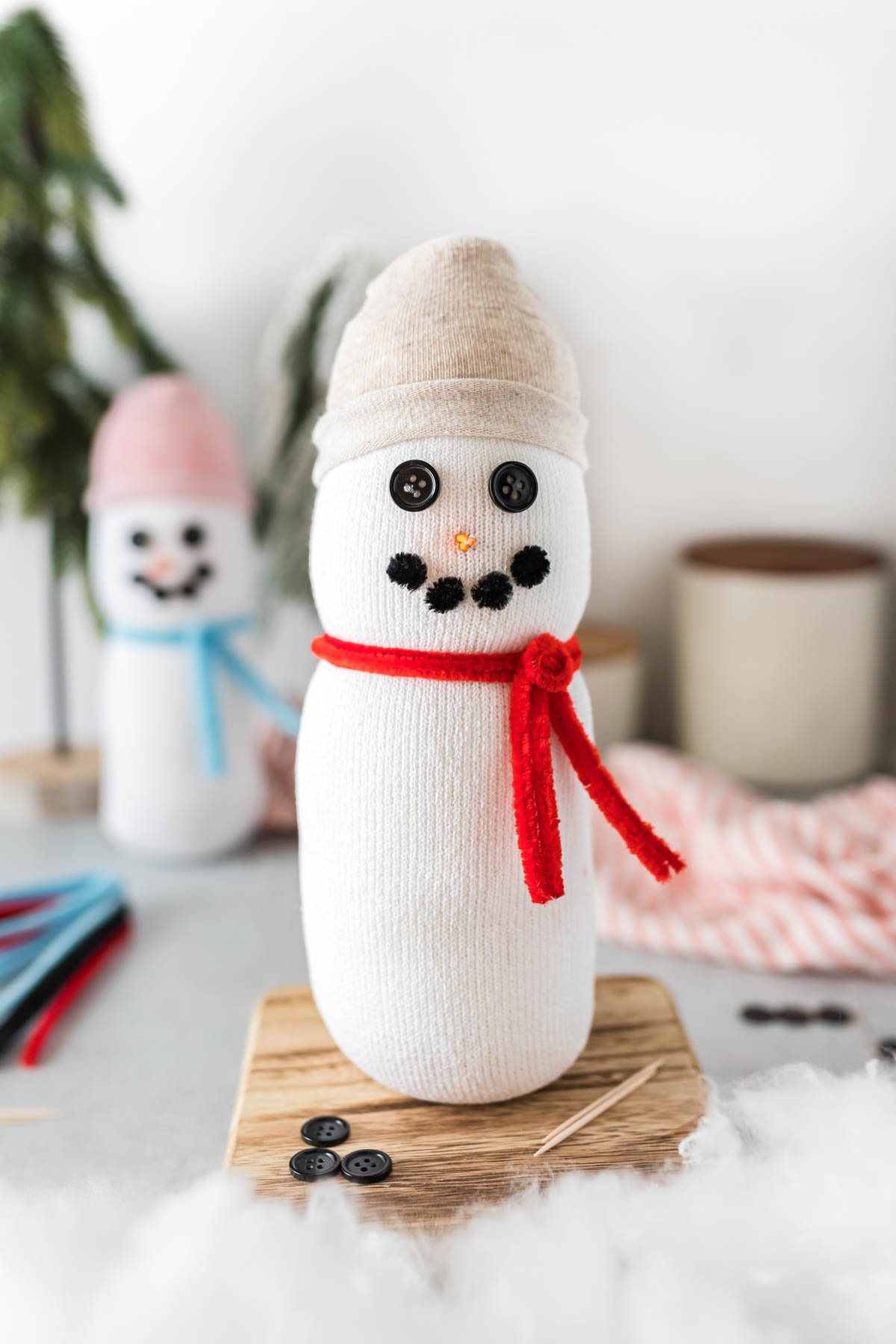 sock snowman craft on a piece of wood