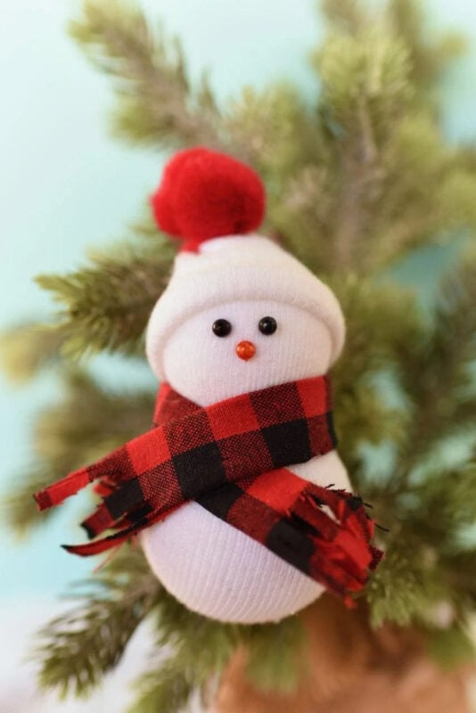 Stuffed baby sock with hat, scarf, and snowman face