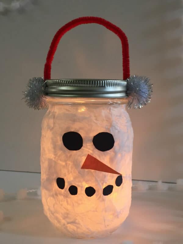 mason jar with white tissue paper and snowman face