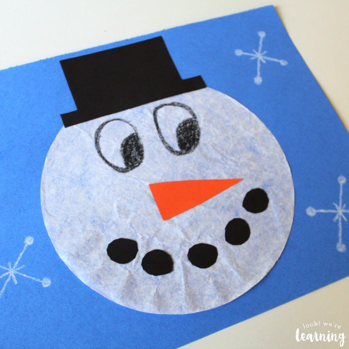 coffee filter with snowman face on a blue sheet of paper