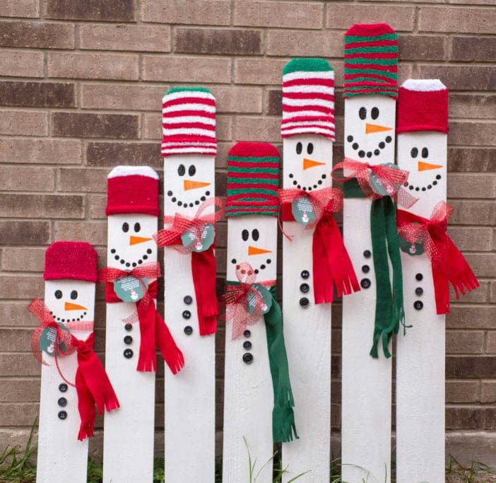 painted wooden board with snowman faces and hats