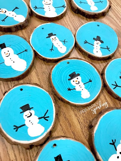 thumbprint snowmen on painted wooden slice