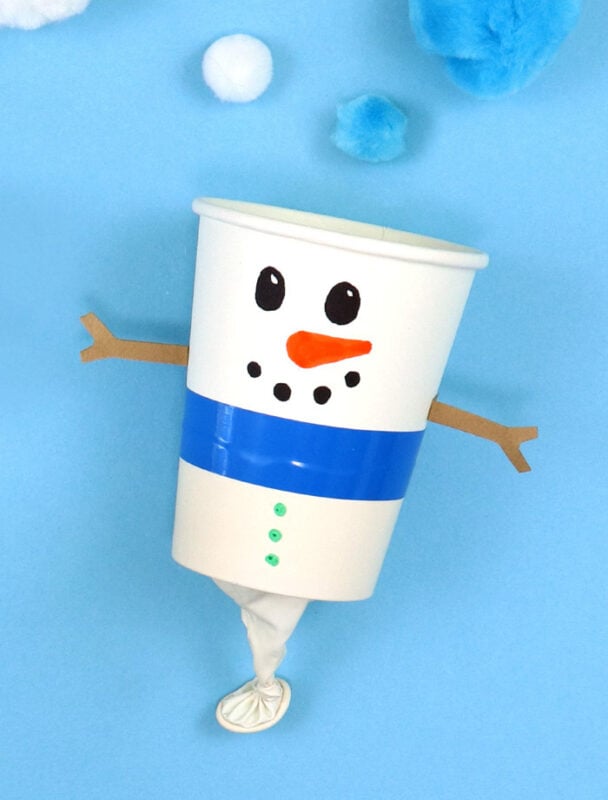 paper cup with balloon attached to the bottom and snowman face drawn on