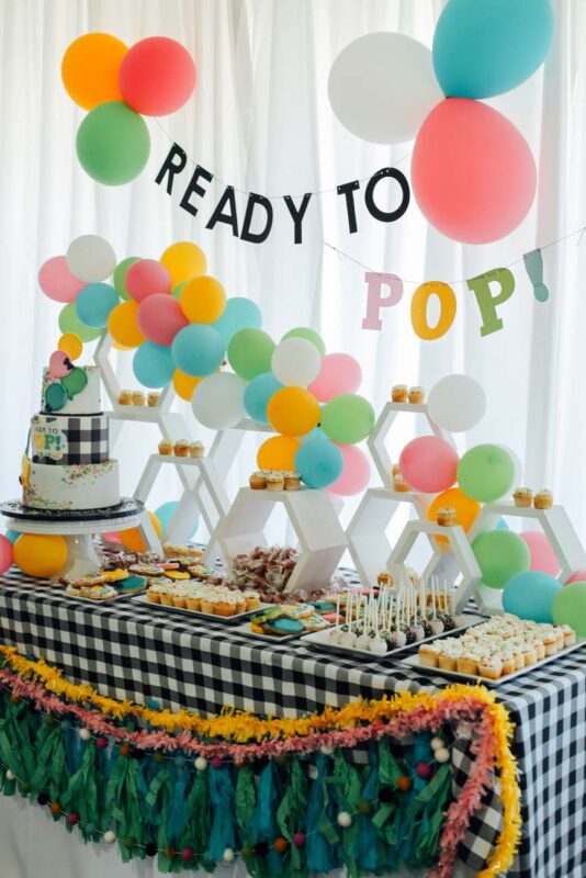 multicolored balloons on a brightly colored dessert table
