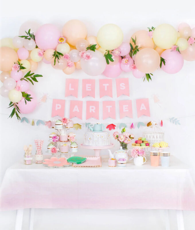 party table set up with various foods and pink background