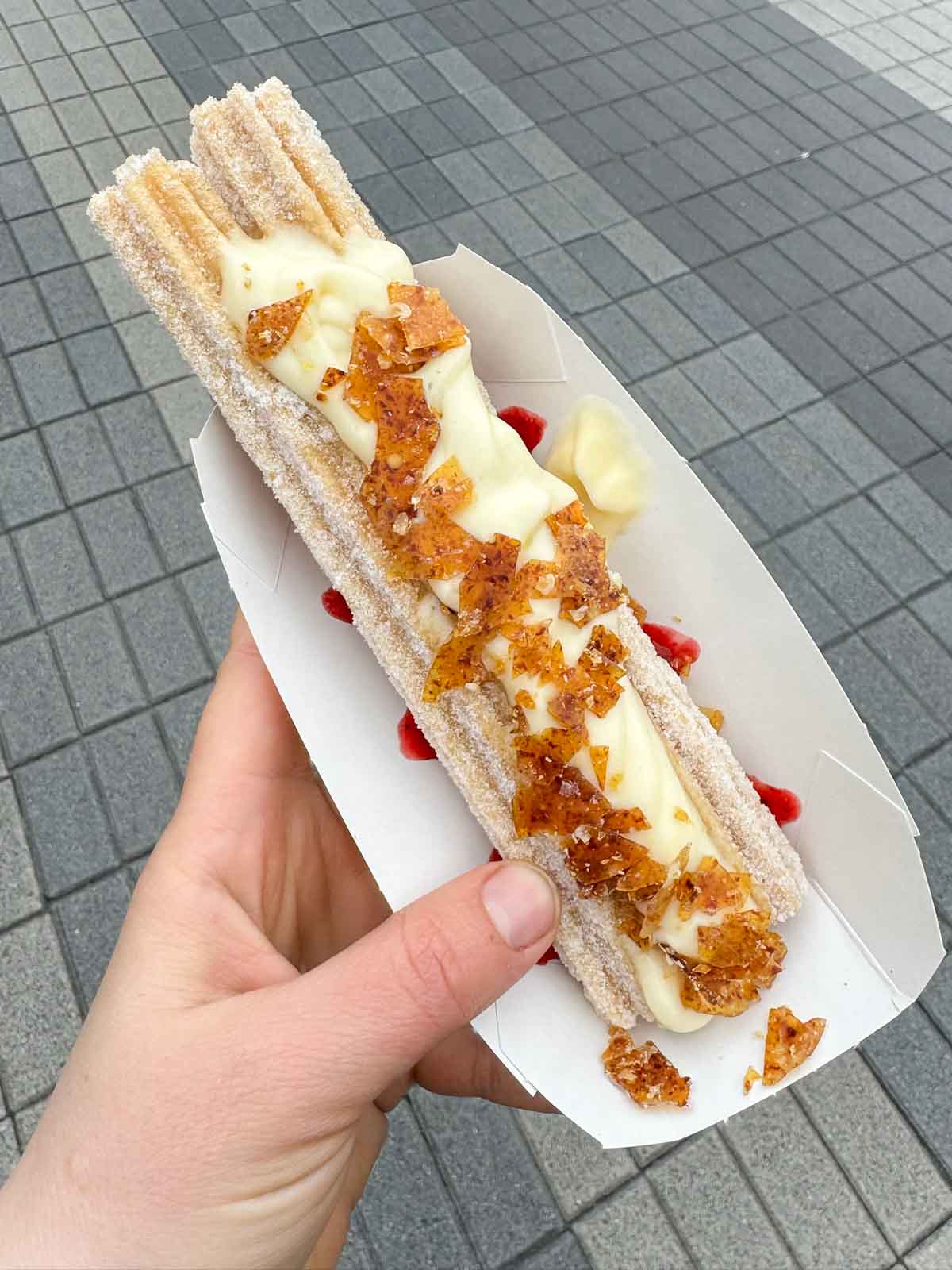 hand holding a strawberry caramel churro 