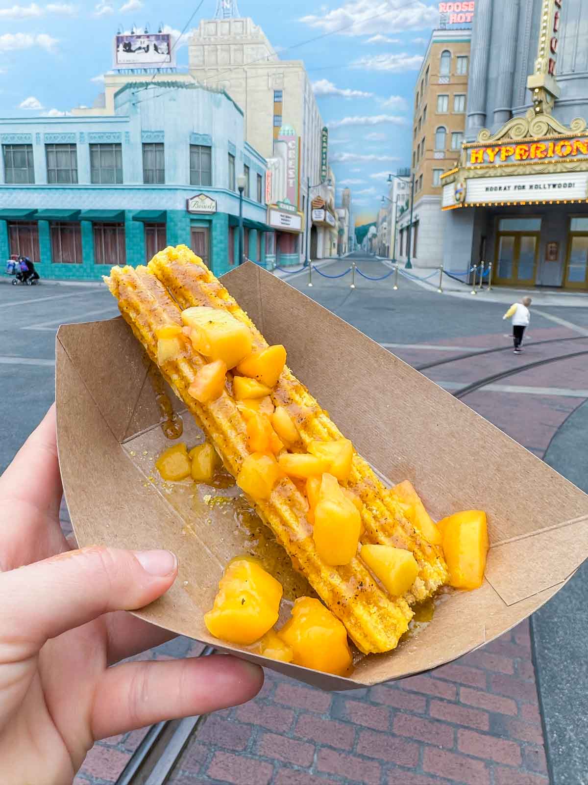 hand holding a peach churro at Disneyland