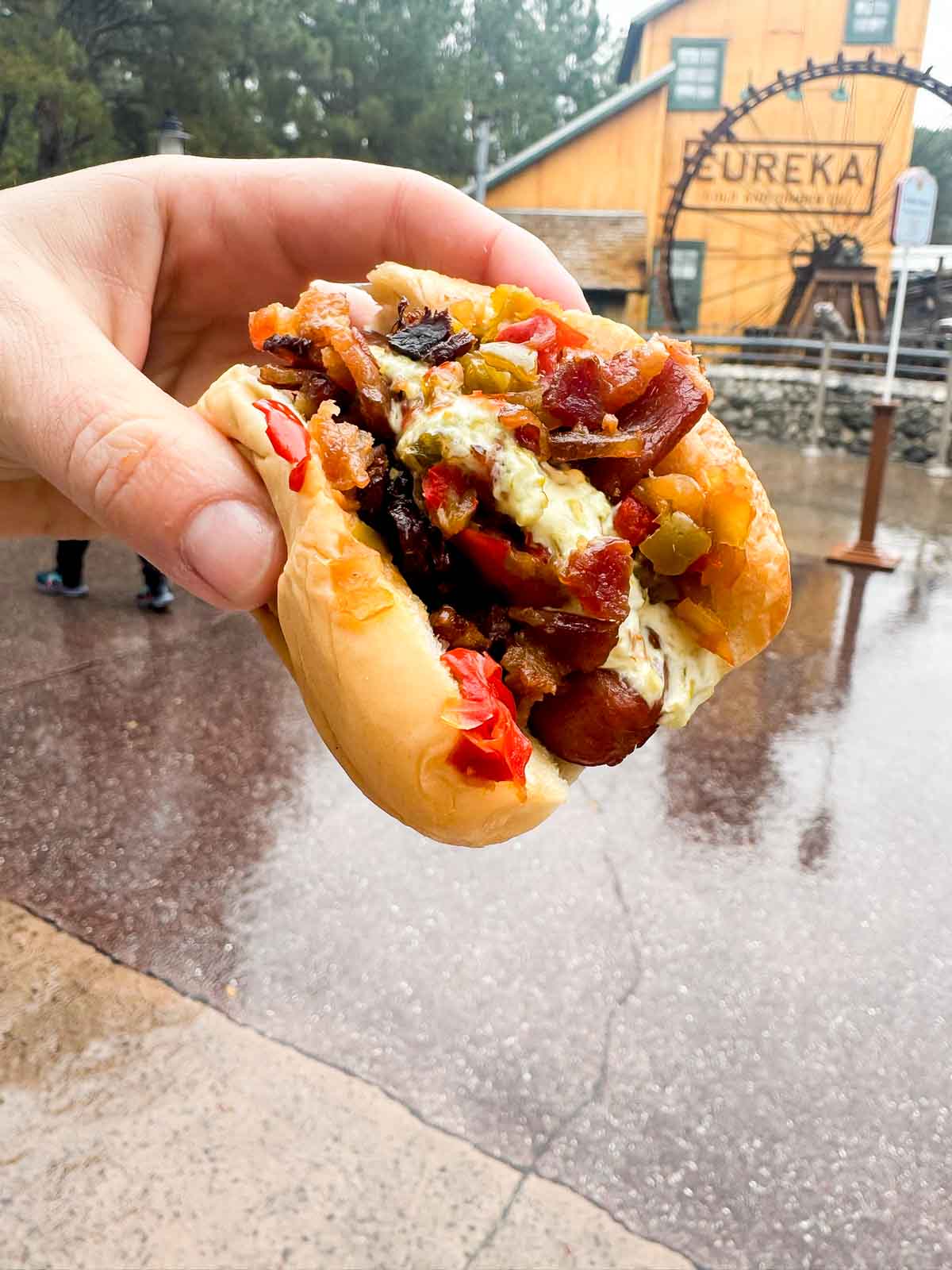 hand holding a mini street dog at Disneyland food and wine festival