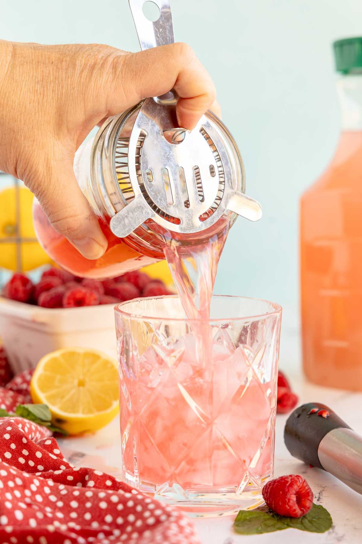 pouring raspberry mocktail over ice 