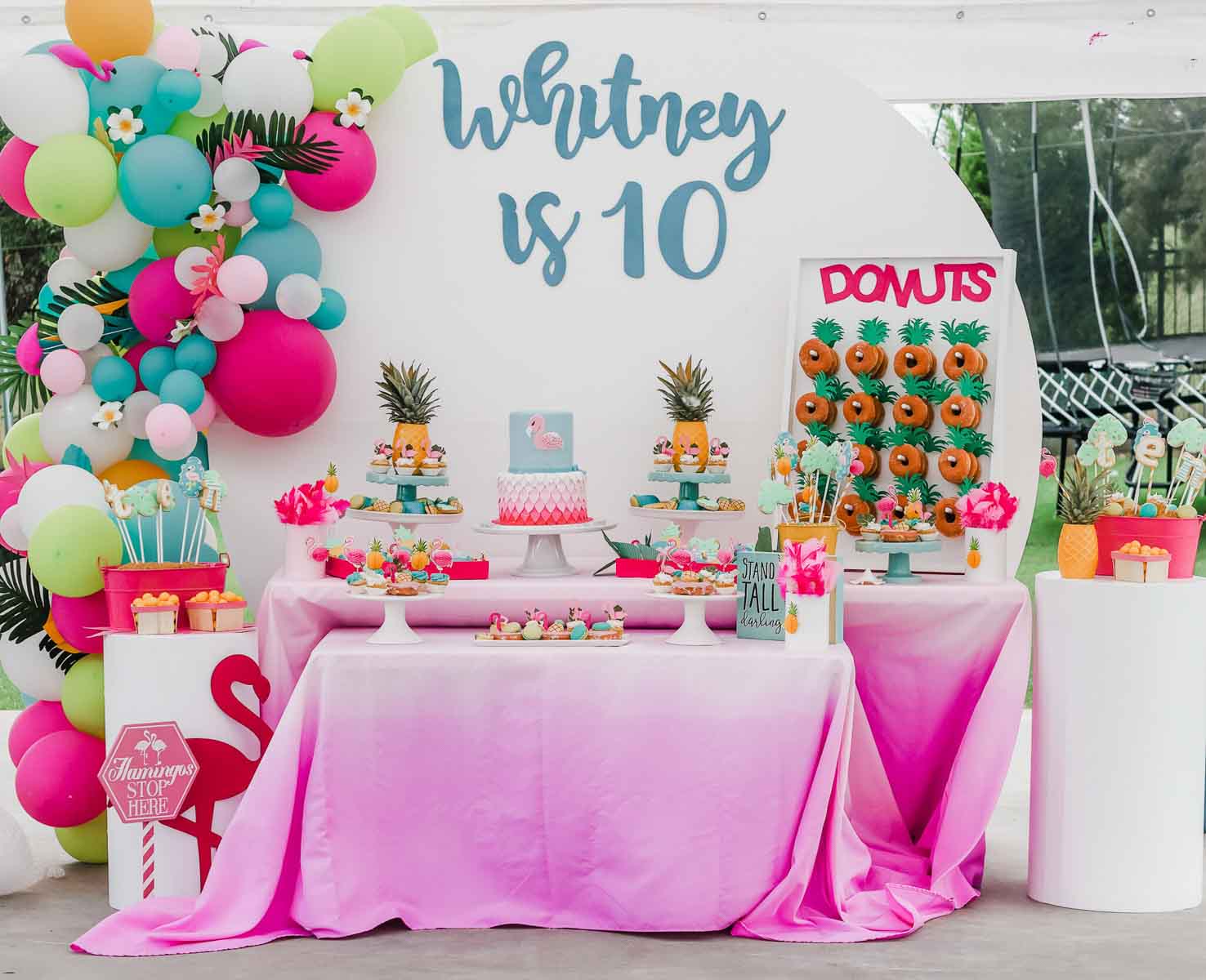 pink party table with a balloon garland