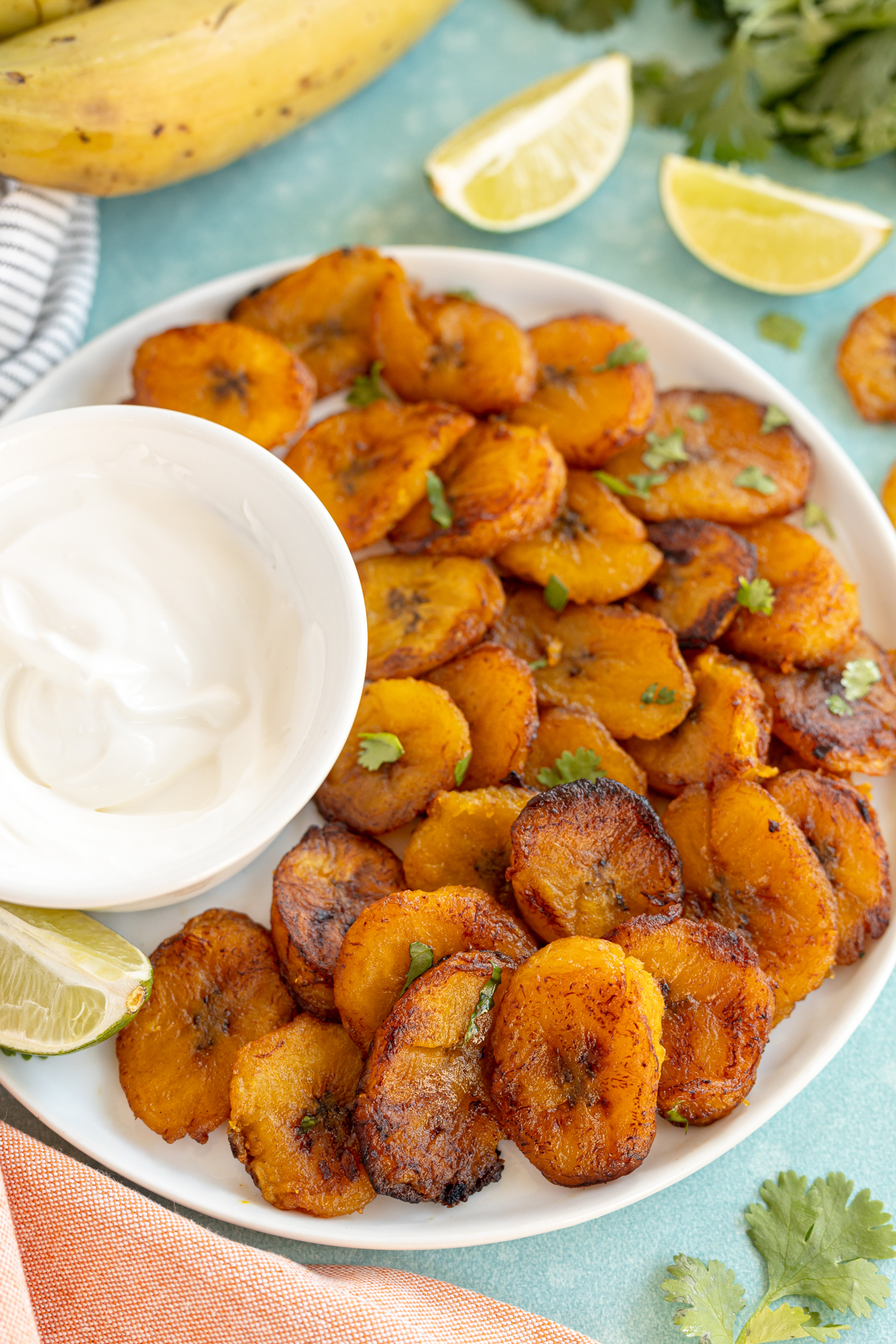 plate of fried sweet plantains with a side of Mexican crema
