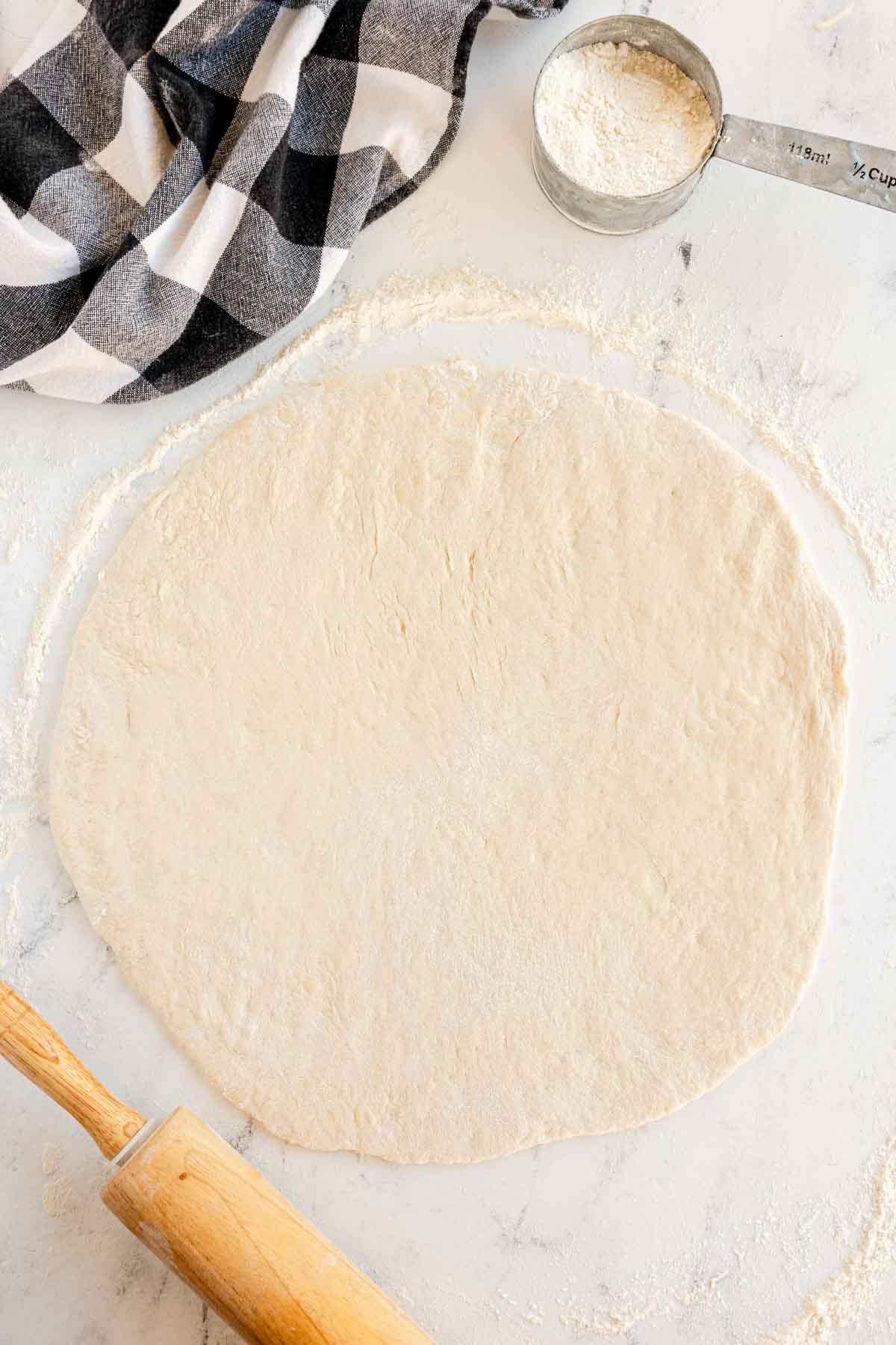 rolled out pizza dough on a floured surface