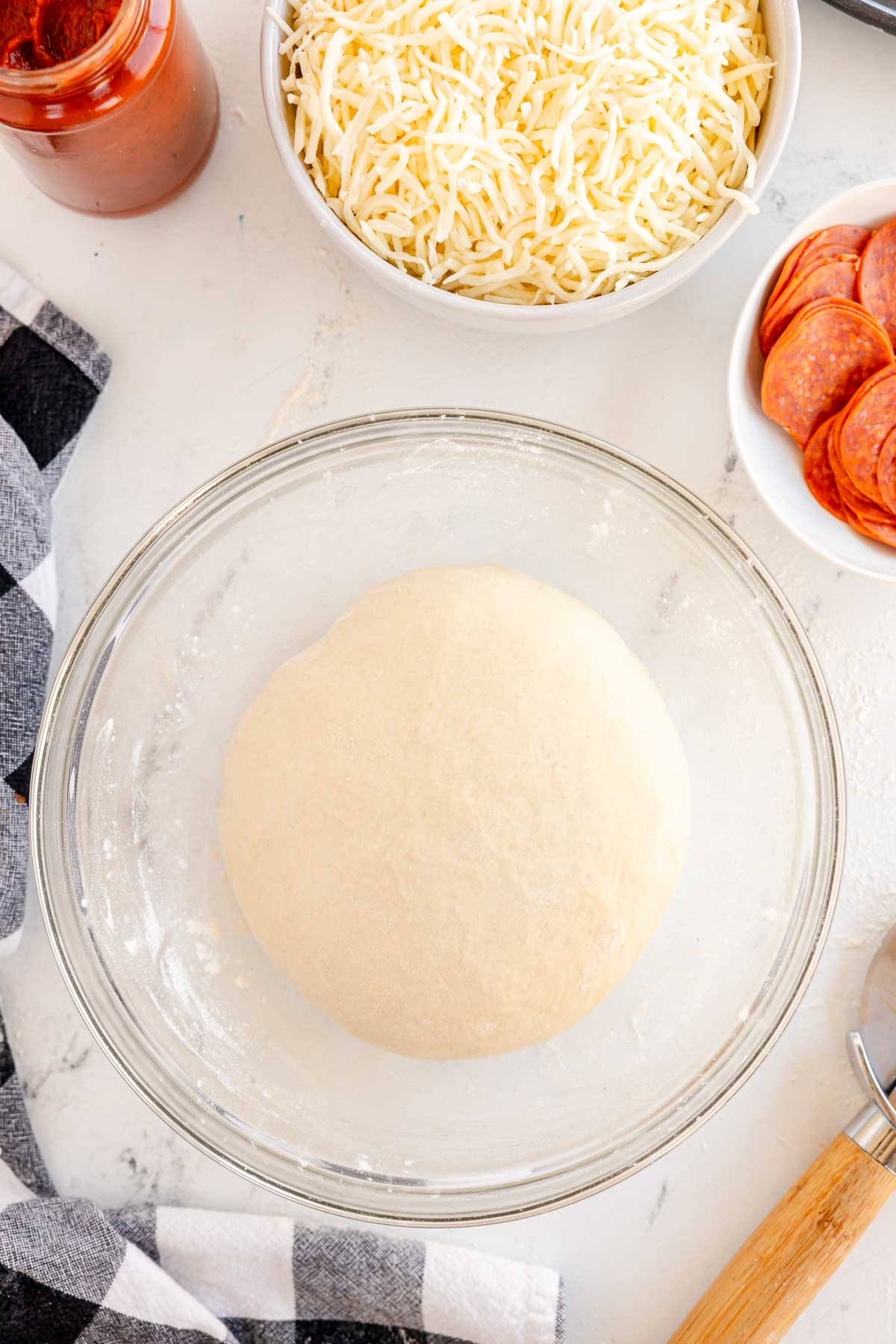 pizza dough ball in a glass bowl