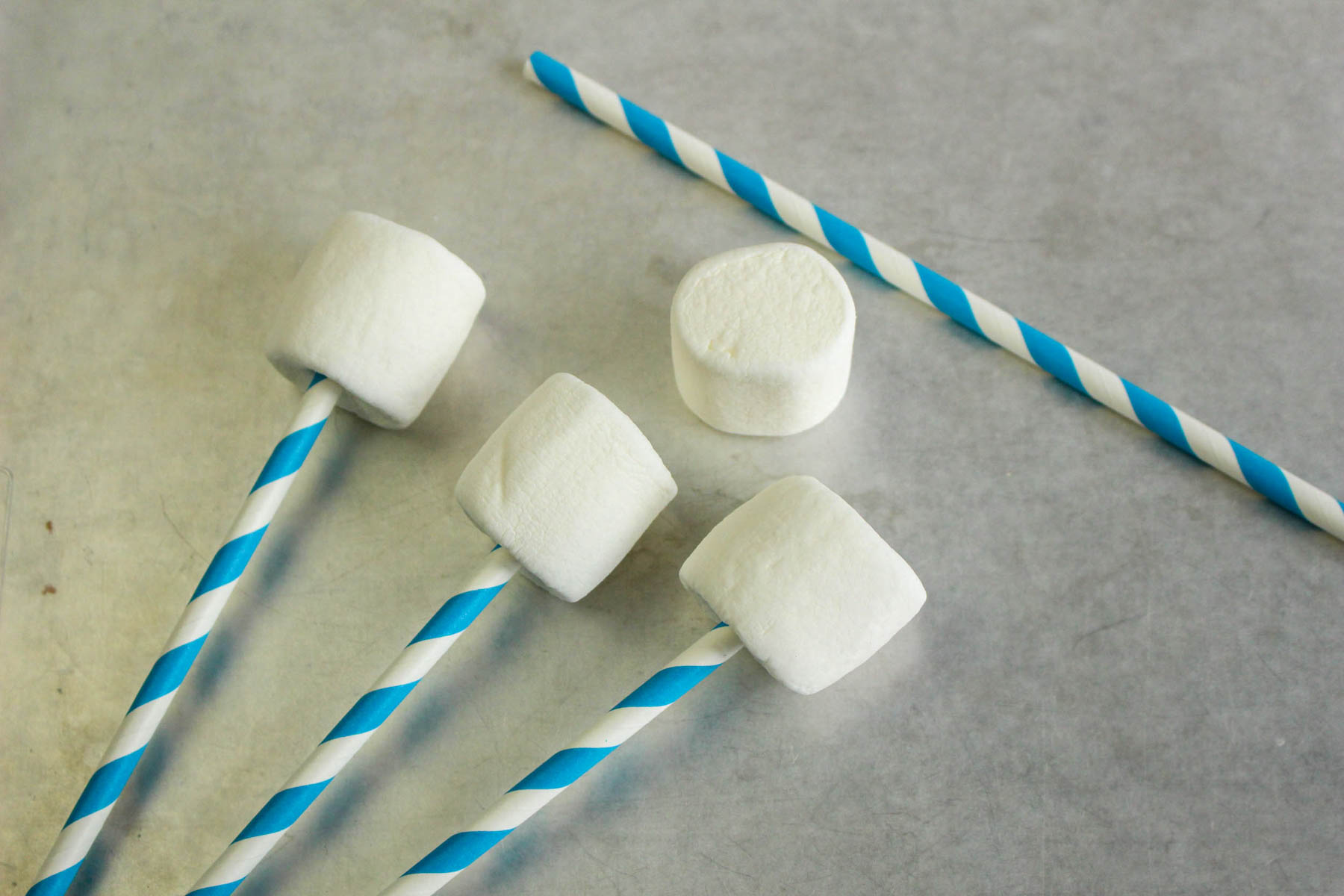 large marshmallows on popsicle sticks