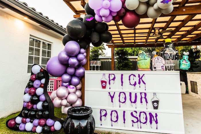 big sign that says pick your poison with balloons nearby