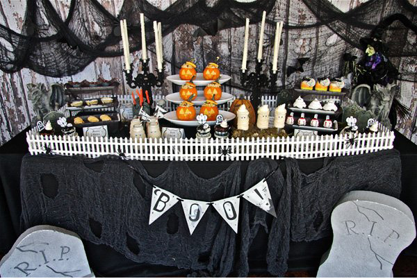 table set up to look like a graveyard with variety of snacks