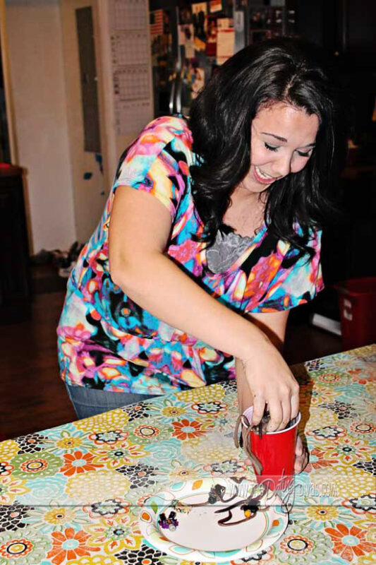 woman reaching hand into a cup of worms