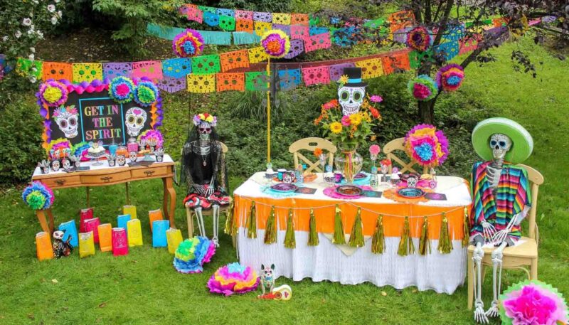 day of the dead table decor with vibrant colors and various posed skeletons