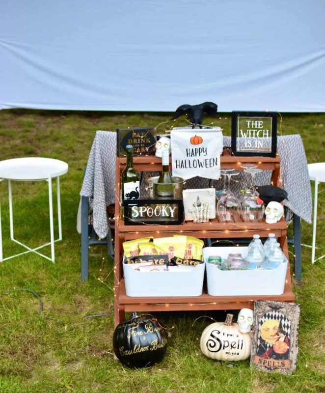 snack cart with popcorn and drinks and decorated with halloween items